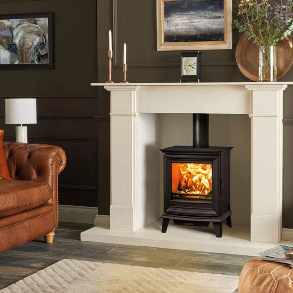 Black wood burning stove inside a cream fireplace surround in a traditional living room